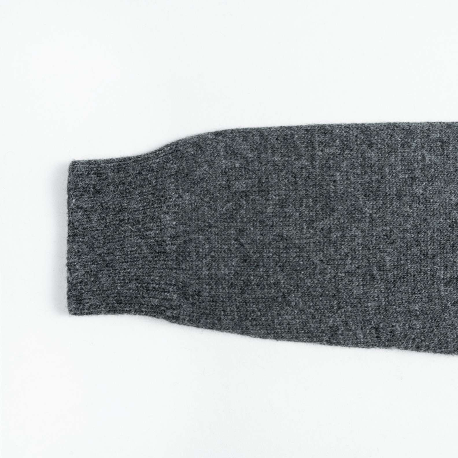 A cozy wool knit cardigan in heather grey. Featuring a classic round neck, a button-front closure, and white geometric intarsia bands across the chest and sleeves. (2)