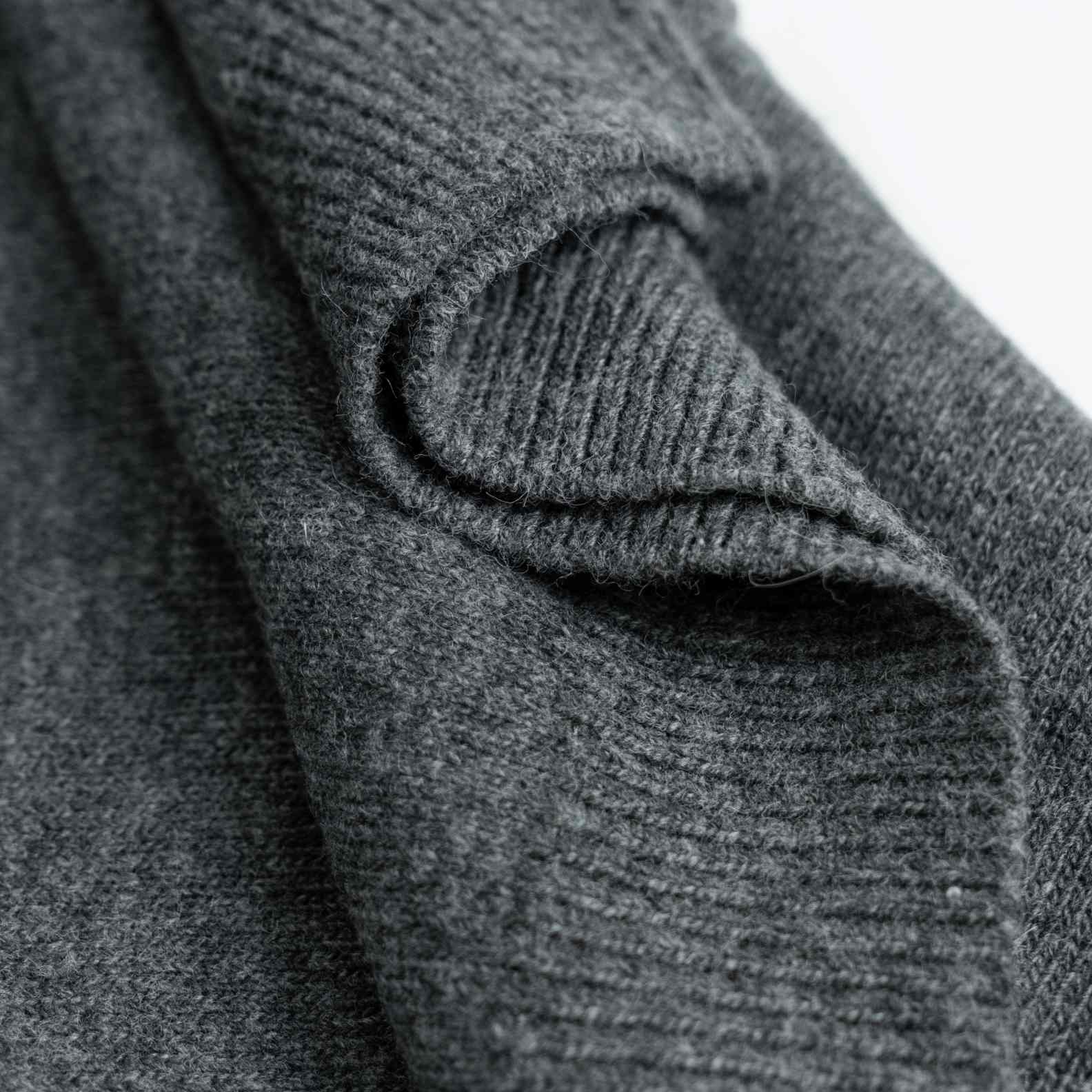 A cozy wool knit cardigan in heather grey. Featuring a classic round neck, a button-front closure, and white geometric intarsia bands across the chest and sleeves. (4)