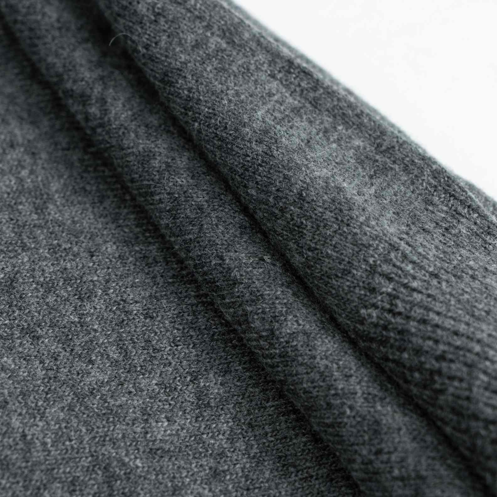 A cozy wool knit cardigan in heather grey. Featuring a classic round neck, a button-front closure, and white geometric intarsia bands across the chest and sleeves. (5)