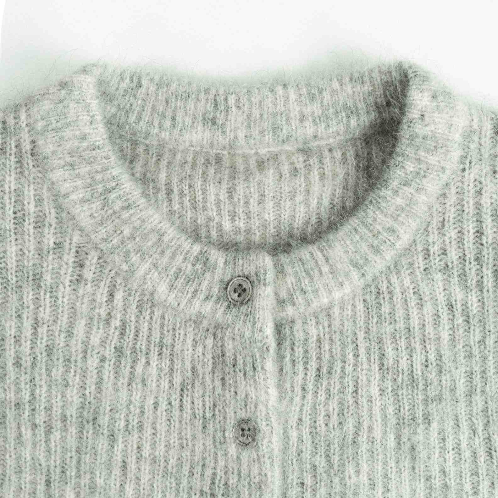 A soft and cozy wool knit cardigan in a versatile light grey heather. Features a classic round neck, a button-front closure, and an all-over vertical ribbed texture. (6)